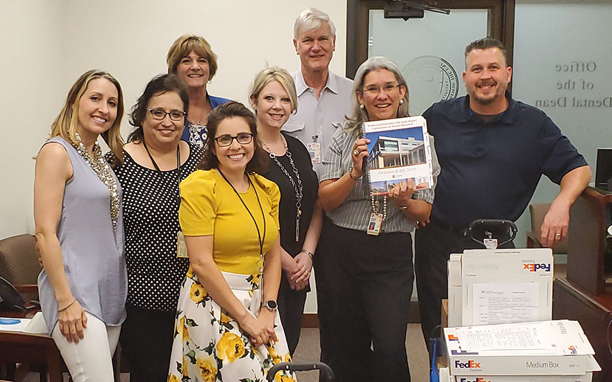The Academics, Faculty and Student Affairs Team gladly wishes farewell to two wagon-loads of self-study manuals.</p>  Front Row (Left to Right): Dr. Stefanie Seitz, Ms. Robin Druckman, Ms. Jennifer Sandlin, Ms. Lori Morgan, Dr. Adriana Segura, Mr. Jason Sandlin.  Back Row: Dr. Dana English and Dr. John Littlefield