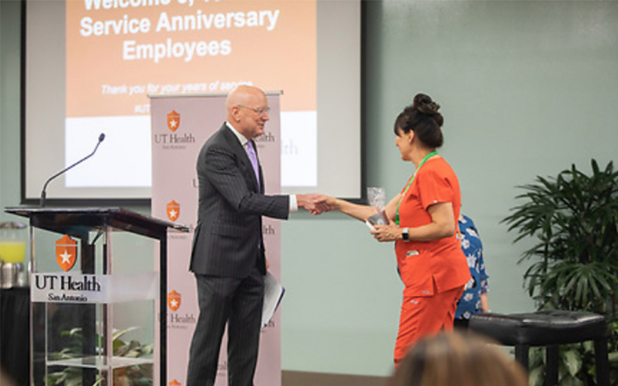 Virginia Carillo, assistant professor in Periodontics, is introduced to President Bill Henrich before she plays a round of trivia.  Carrillo celebrates 5 years. Photo Courtesy of Creative Media Services.