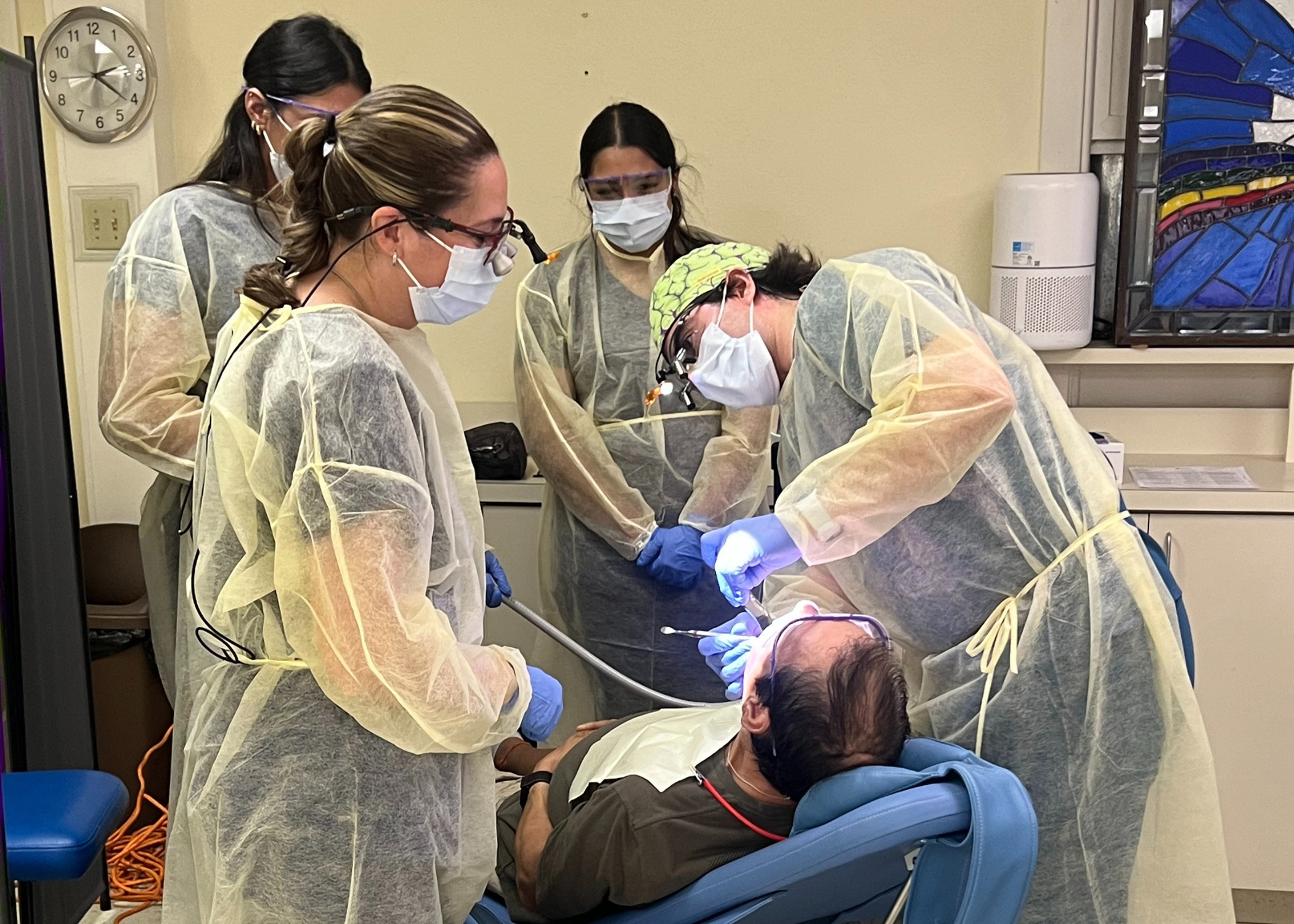 Dentist and students examining patient